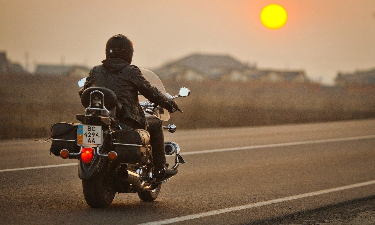 Мотоцикл едет по дороге. Мотоцикл на закате. Мотоциклист на закате. Мотоцикл для путешествий. Байкер на закате.